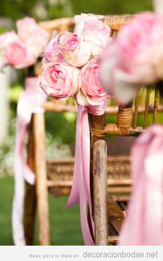 Decoración rosas rosas para sillas de madera en jardín