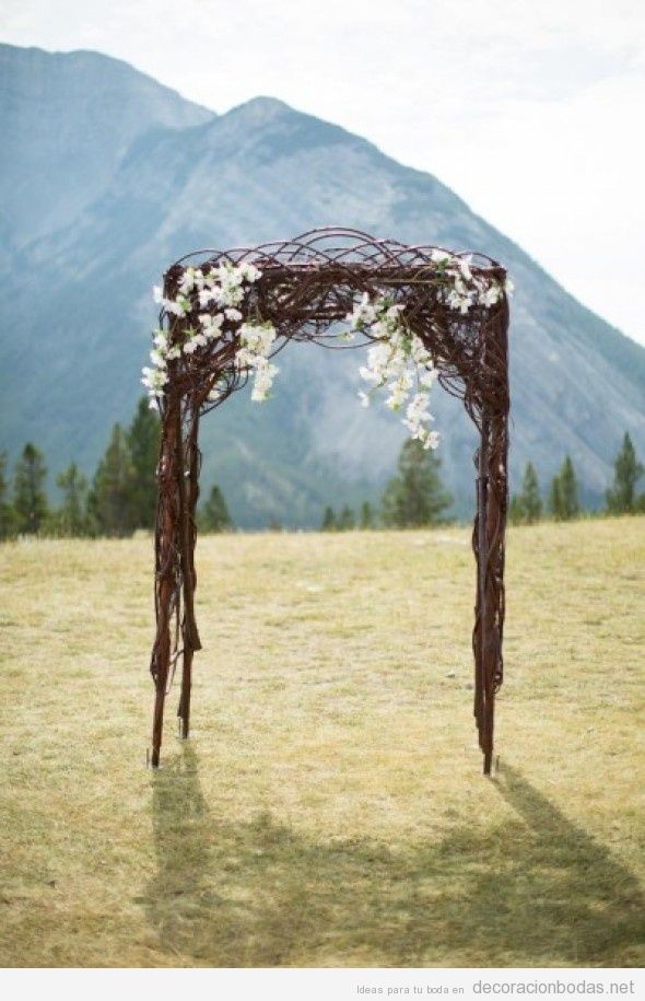 Altar de boda hecho con ramas y flores, sencillo y natural