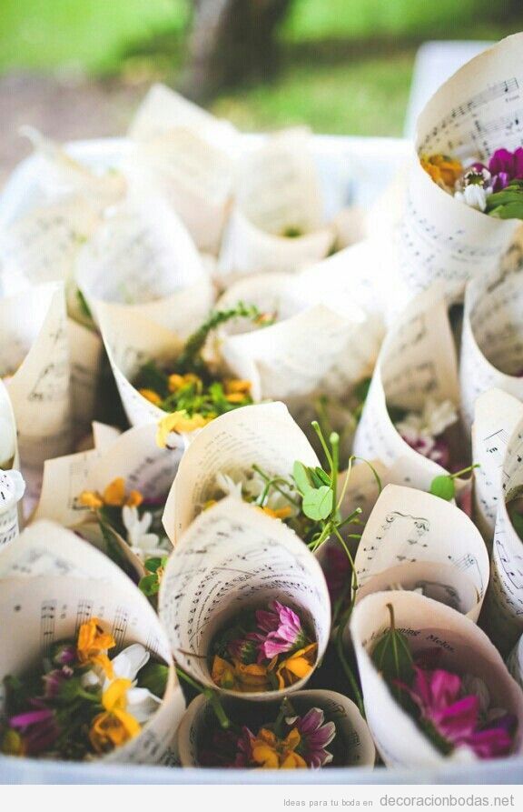Cucuruchos de papel hechos con partituras y flores dentro