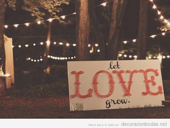 Un hilorama con la palabra LOVE, idea para decorar un jardín en una boda