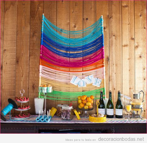 Mesa con bebidas y comida decorada con hilos de colores